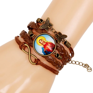 Detail of multi-layer leather bracelet with butterfly, infinity charms and religious portrait