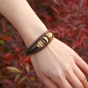 Multilayer leather bracelet with braided cords, wooden beads, and a sparkling crystal ring