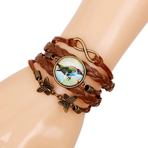 Detail view of woven brown leather bracelet with kingfisher pendant and butterfly charms
