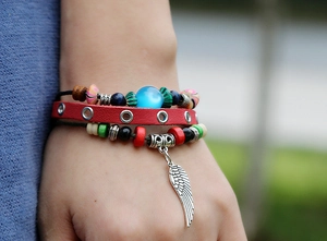 Bohemian multi-layer red leather beaded bracelet featuring a silver wing charm