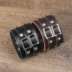 Punk style wide leather wristbands in black and dark brown with metal rivets and studs
