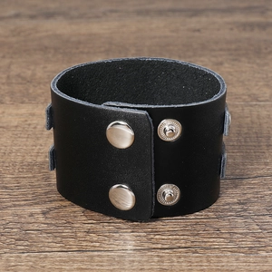 Detailed view of broad black leather punk bracelet with silver metal snap fasteners