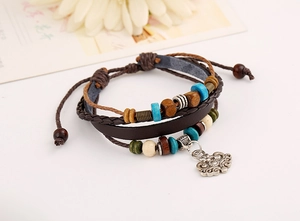 Macro detail of multi-layer leather bracelet with wooden beads and silver hollow charm