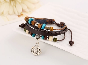 Detail of bohemian layered leather bracelet with turquoise beads and silver hollow charm