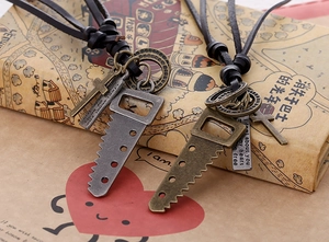 Macro shot of vintage leather necklaces featuring saw and cross charms on an old book
