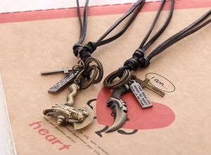 Detail of vintage axe and cross charms on leather cord necklaces with rustic packaging