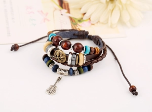 Detail of multilayer vintage leather bracelet with wooden beads and guitar charm