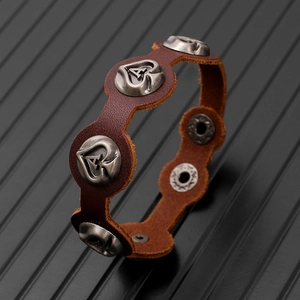 Macro detail of retro leather bracelet with heart A metal charm and rustic stitching