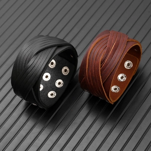Gros plan de bracelets en cuir tressé multicouche faits main avec boutons-pression en métal
