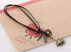 Detail of vintage bronze axe and cross pendants on black cord necklace for men