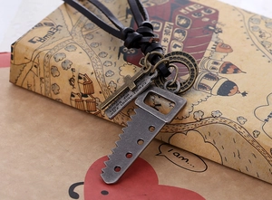 Macro detail of retro cowhide necklace with cross and antique metal charms on vintage map