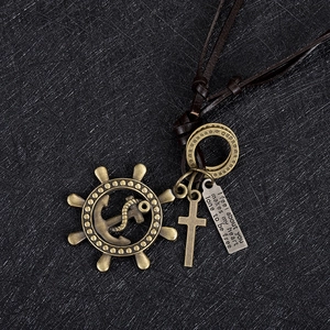 Detail of vintage bronze nautical necklace with steering wheel and anchor on leather cord