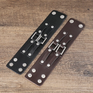 Detail of punk style wide cowhide bracelets with silver metal rivets in black and brown