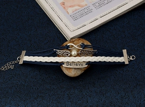 Detail of multi-layer woven bracelet featuring wings, infinite symbol and Believe charm