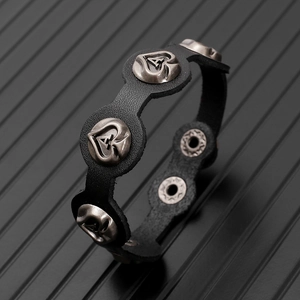 Detail of black leather punk bracelet featuring heart studs with A letter engraving