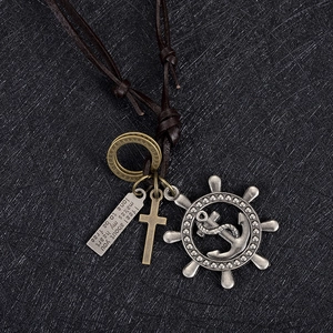 Macro shot of retro leather necklace featuring rudder, anchor and cross pendants