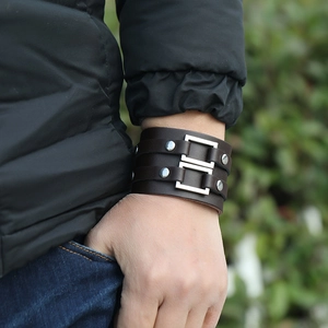 Detail of dark brown leather punk bracelet with double straps and silver metal buckles