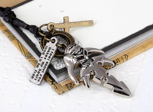 Close-up of punk leather necklace featuring skull, cross, and engraved poem charms