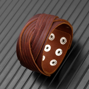 Détail d'un bracelet en cuir multicouche marron foncé avec six boutons-pression argentés