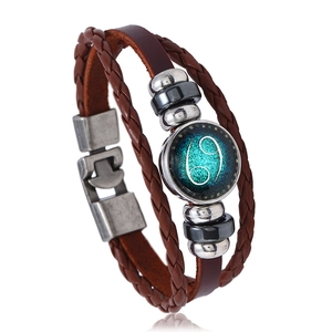 Detail of multi-layer woven brown leather bracelet with Cancer zodiac sign and beads
