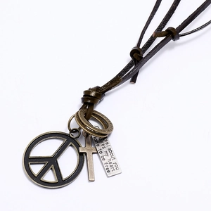 Detail of adjustable leather cord necklace with bronze peace sign and cross pendant