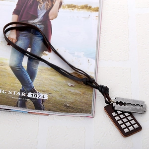 Retro leather necklace with vintage razor blade and rivet pendant on a magazine