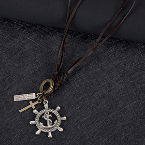 Close-up of vintage leather necklace with antique silver helm and bronze cross charms
