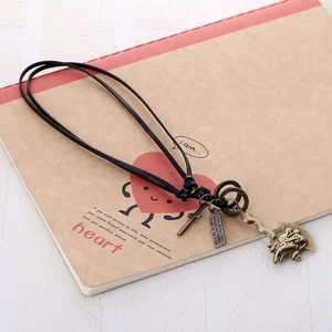 Vintage bronze alloy multi-pendant necklace with cross and tribal totem on a notebook