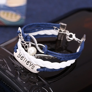 Blue and white braided bracelet with Believe charm, wings, and infinity symbol