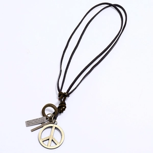 Detail of vintage leather necklace with antique bronze peace sign and engraved pendants