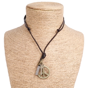 Detail of vintage peace sign and cross charms on a dark brown leather cord necklace