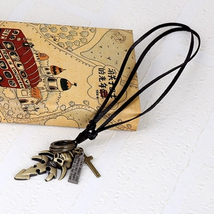 Retro punk style long leather necklace with skull and cross charms on vintage book
