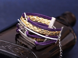 Détail d'un bracelet bohème multicouche avec pendentif vélo et citation gravée sur métal