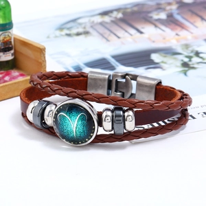 Close-up of vintage Aries constellation leather bracelet with woven layers and metal clasp