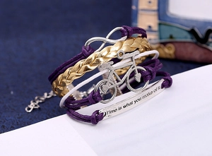 Détail du bracelet tressé avec pendentif vélo et plaque métallique gravée de motivation