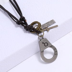 Close-up of vintage leather necklace featuring bronze cross and 520 handcuff charms