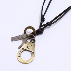 Close-up of vintage leather necklace with bronze alloy cross and engraved charms