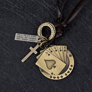 Détail macro de pendentifs en bronze rétro avec croix et poker sur cordon en cuir brun