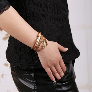 Detail of vintage braided leather bracelet with infinity charm and anchor on wrist