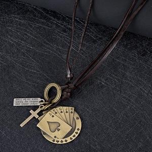 Détail de cartes de poker vintage en bronze et pendentif croix sur collier en cuir
