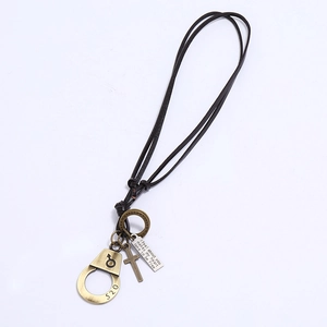 Detail of vintage bronze couple necklace with 520 handcuffs, cross and engraved plate