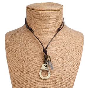 Detail of vintage leather necklace with 520 handcuff, cross and engraved metal charms
