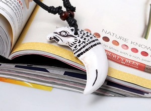 Close-up of eagle head pendant with resin carving and black braided rope necklace