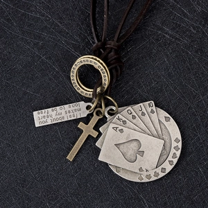 Détail du collier en cuir vintage avec pendentifs cartes de poker et croix sur fond noir