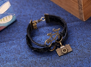 Vue détaillée du bracelet multicouche tressé avec breloques vélo et appareil photo rétro