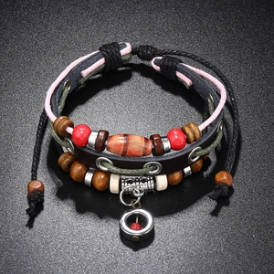 Detail view of multi-layer beaded leather bracelet with ethnic charms and woven ropes