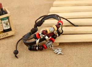 Détail macro du bracelet multicouche en cuir tressé avec perles et pendentif dragon