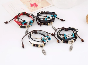 Detail of bohemian leather bracelets with turquoise beads and silver feather charms
