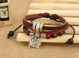 Dettaglio del bracciale multistrato in pelle vintage con teschio pirata e perline in legno