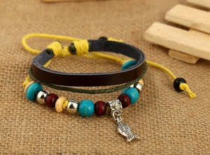 Détail d'un bracelet bohème en cuir multicouche avec perles et pendentif poisson argenté